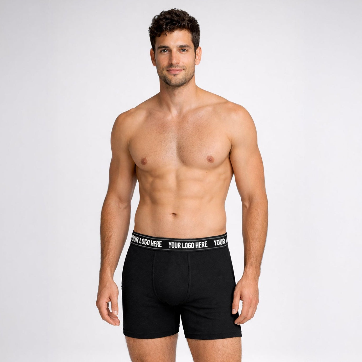 Man wearing black boxer briefs with customizable waistband on a white background